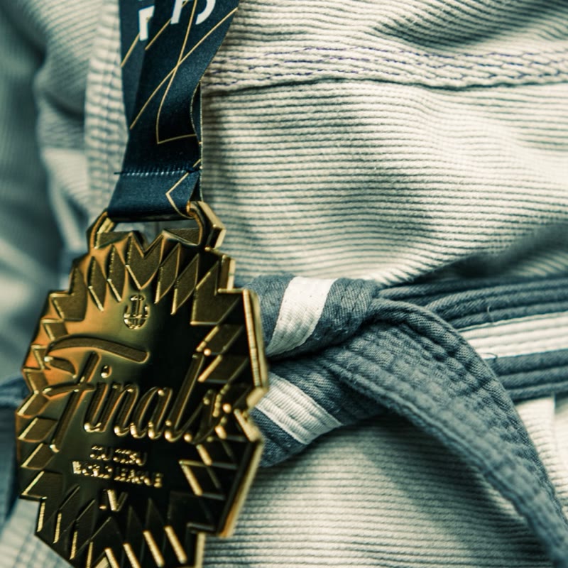 Close-up of JJWL Finals gold medal on gi